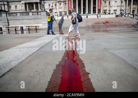 London, Großbritannien, 09 2020. Aug: Extinction Rebellion-Aktivisten decken `gefälschtes Blut über die Treppe des trafalgar Square zum Internationalen Tag der Welt Stockfoto